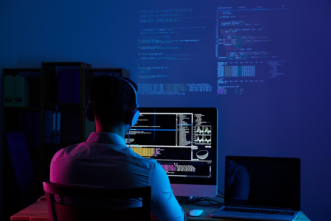 Developer working at a desk with code on the screen