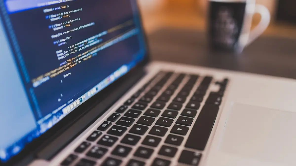 Laptop mit Code in einem dunklen Raum